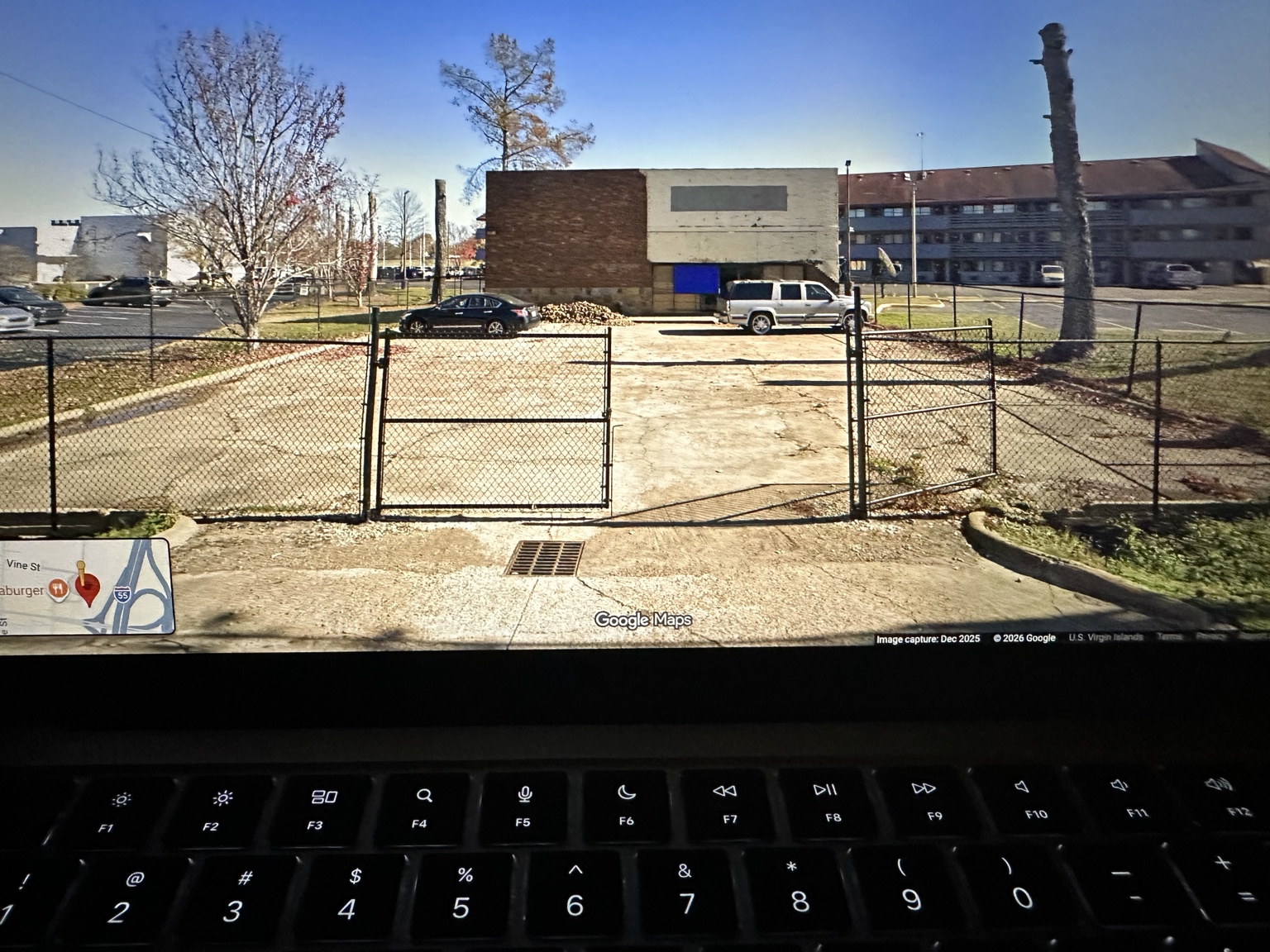 Small building and fenced parking lot immediately west of the Red Roof Inn
